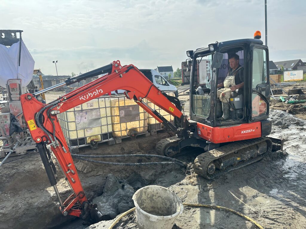 Grondwerk en graafmachine bij de bronboringen voor nieuwbouwwoningen in Tholen